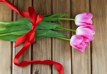 Top view of pink tulips with red ribbon and bow