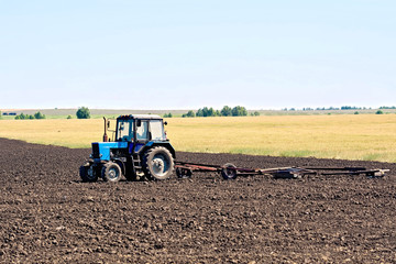Fototapeta na wymiar Tractor wheeled plowing