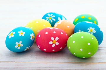 Fototapeta na wymiar Easter eggs on white wooden desk. Festive background toning 