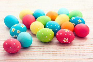 Easter eggs on white wooden desk. Festive background toning 