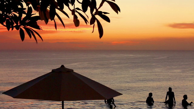 Edge of infinity swimming pool overlooking ocean at sunset