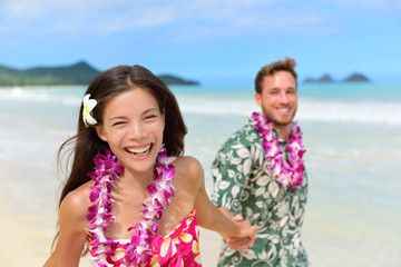 Fototapeta na wymiar Happy Hawaii beach holiday couple in Hawaiian leis