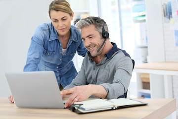 Colleagues in office working on laptop computer