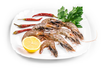 Raw shrimps on plate with lettuce and lemon.