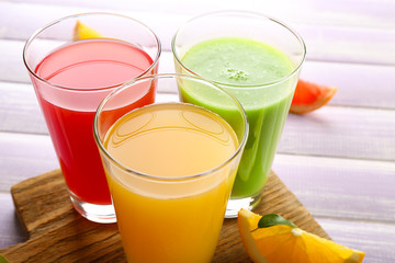 Fresh juices with fruits on wooden table