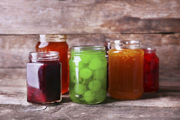 Fototapeta na wymiar Homemade jars of fruits jam on rustic wooden background