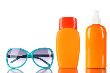 Bottles of suntan cream with sunglasses isolated on white