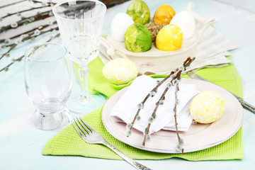 Easter table setting on color wooden background