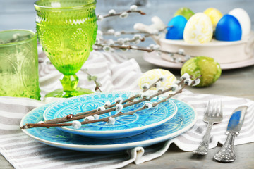 Easter table setting on color wooden background