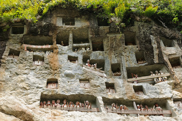 Ancient forged tombs in rock guarded by puppets