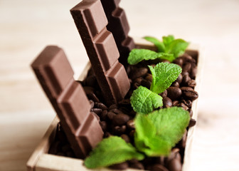 Still life with set of chocolate in wooden box of coffee grains