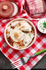 Tasty dumplings with fried onion in brown bowl,