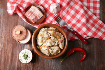 Fried dumplings with onion and bacon in frying pan,