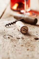 Wine cork and corkscrew on wooden table, wine bottle and glass