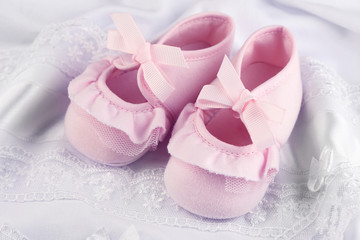 Obraz na płótnie Canvas Pink baby boots on cloth close-up
