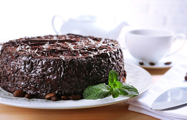 Tasty chocolate cake with cup of tea on table close up