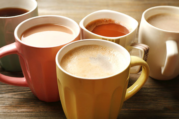Many cups of coffee on wooden table, closeup