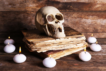 Still life with human skull, retro book and candlelight