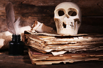 Still life with human skull, retro book and quill