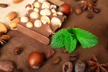 Chocolate with mint, spices and coffee beans on table, closeup
