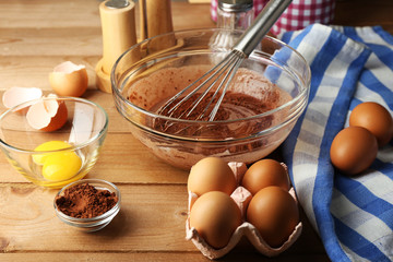 Fototapeta na wymiar Preparation cream with eggs and cocoa in glass bowl