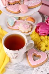 Composition of spring flowers, tea and cookies on table
