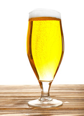 Glass of beer on wooden table, isolated on white
