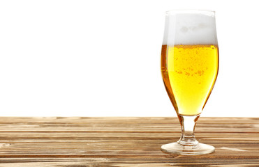 Glass of beer on wooden table, isolated on white