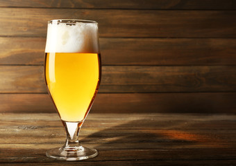Glass of beer on wooden background