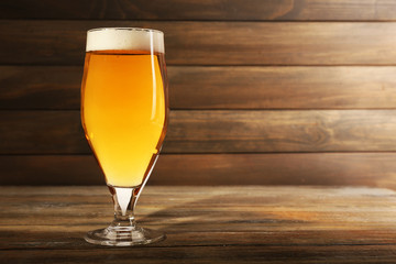 Glass of beer on wooden background