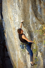 Rock climber climbing up a cliff