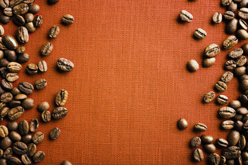 Frame of coffee beans on color sackcloth background