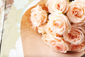 Bouquet of beautiful fresh roses on old wooden table, closeup