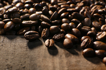 Pile of coffee beans on wooden table, closeup