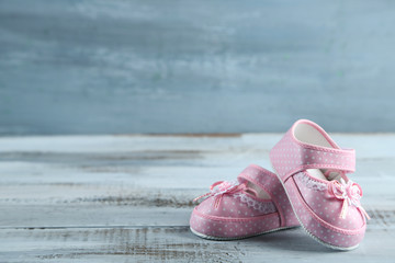 Pink toddler shoes on wooden background