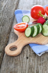 Cucumbers and tomatoes on a cutting board