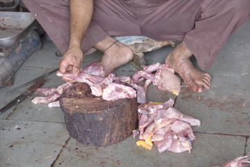 Poultry cutting at a street restaurant in Old Delhi, India.