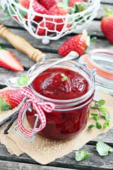 Homemade delicious strawberry jam on a rustic wooden table