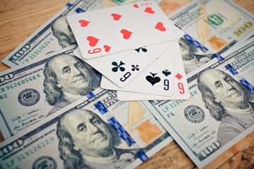 Four aces poker playing cards among U.S. dollar banknotes