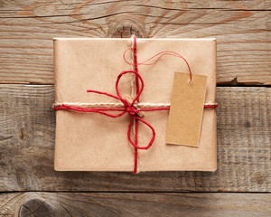 Gift box with tag close-up on wooden background