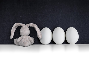 Easter Bunny with white eggs on the black chalkboard - 80934096