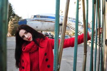 Girl in red on a background of old airplane