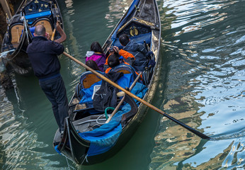 Obraz premium Venetian gondolier punting gondola in Venice Italy