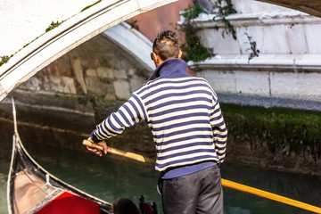Venetian gondolier punting gondola in Venice Italy