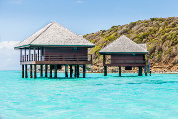 Two Buildings on Stilts Above Tropical Water