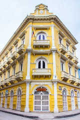 Fototapeta na wymiar Hermosa fachada de un edificio colonial de la ciudad amurallada de Cartagena de Indias en Colombia. Edificio amarillo