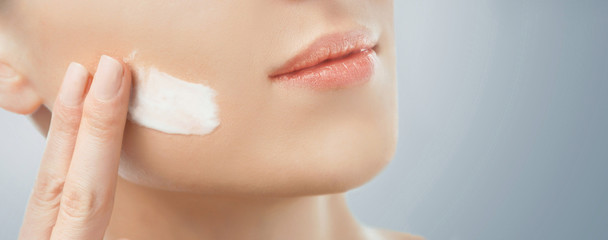 Obraz na płótnie Canvas Woman applying facial cream