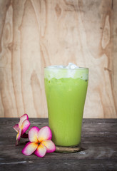 Iced Milk Green Tea on a wooden table in summer