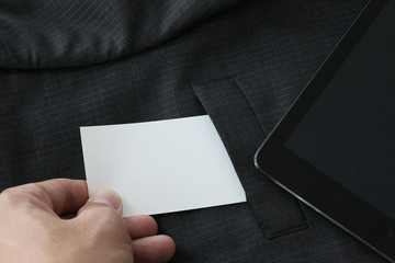 close up of hand picking blank business card from gray suit pock