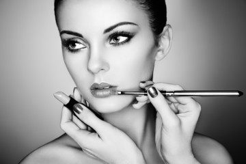 Makeup artist applies lipstick